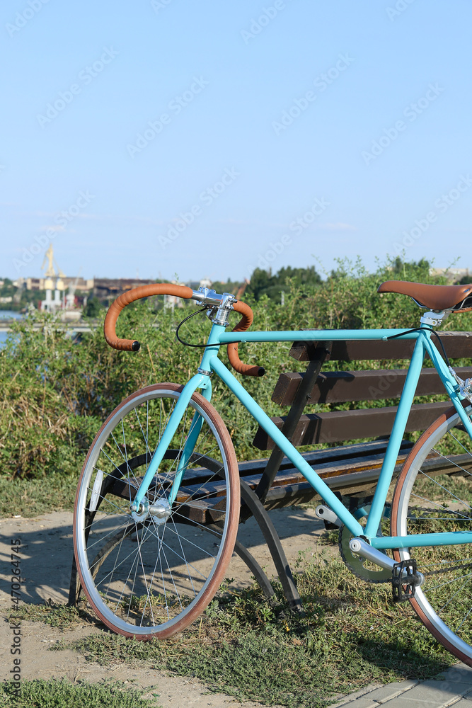 Sporty stylish bicycle in park near bench Sporty stylish bicycle in park near bench