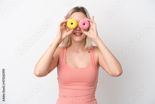 Young caucasian woman isolated on white background holding donuts in eyes