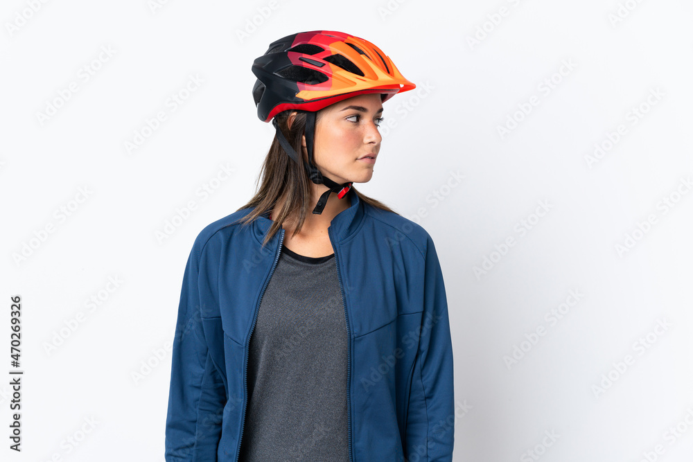 Young cyclist brazilian girl isolated on white  background looking to the side