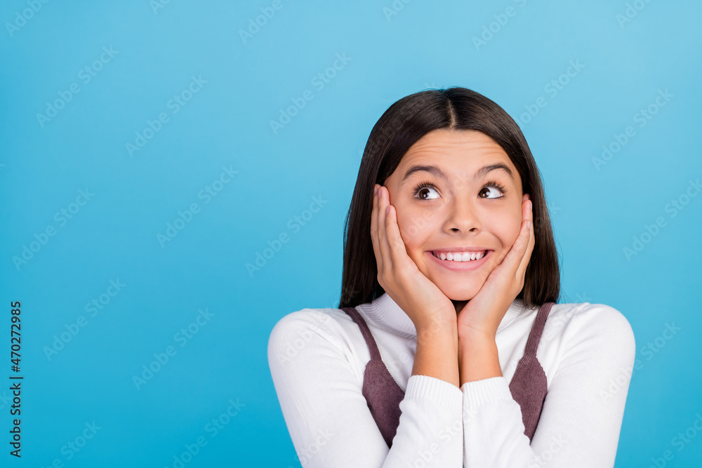 Photo of thoughtful dreamy student girl wear brown dress smiling looking empty space arms cheeks isolated blue color background