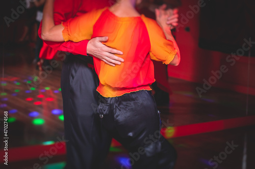 Couples dancing traditional latin argentinian dance milonga in the ballroom, tango salsa bachata kizomba lesson in the red lights, dance festival