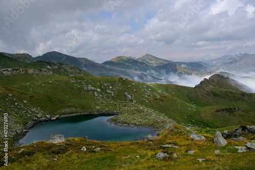 Fototapeta Naklejka Na Ścianę i Meble -  Beautiful mountain lake, view above clouds during hiking on peak Djeravica (Gjerovica) - the highest peak of Kosovo. Albanian Alps, Peaks of Balkans