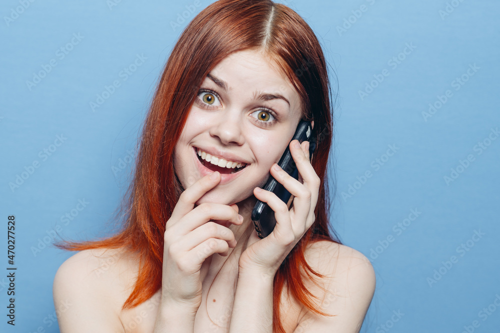 woman with red hair bare shoulders talking on the phone woman with red hair bare shoulders talking on the phone