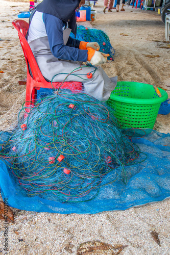 Repair and inspection of a fishing net at the beach  © Willi