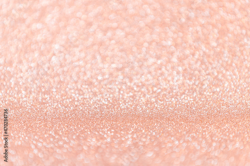 Abstract blurred coral or peach magic glitter background with copy space.