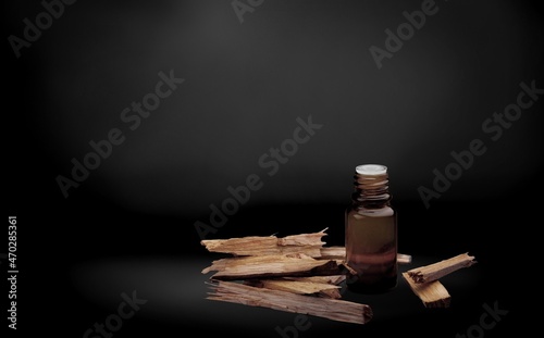 Oud Oils bottle with agarwood on dark background photo