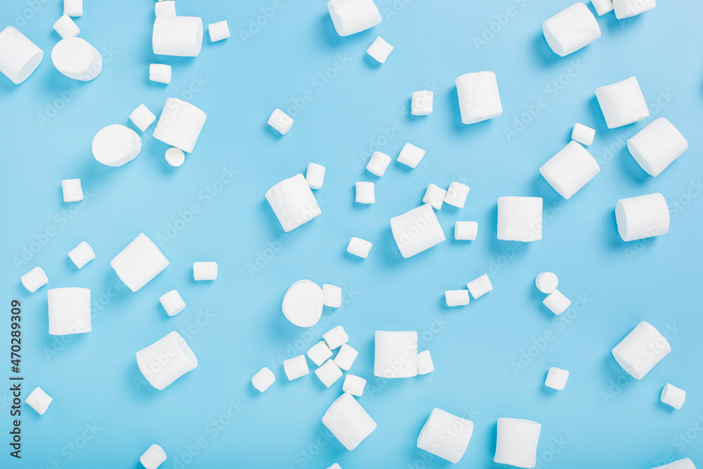 White marshmallows on a blue background. Top view, flat lay.