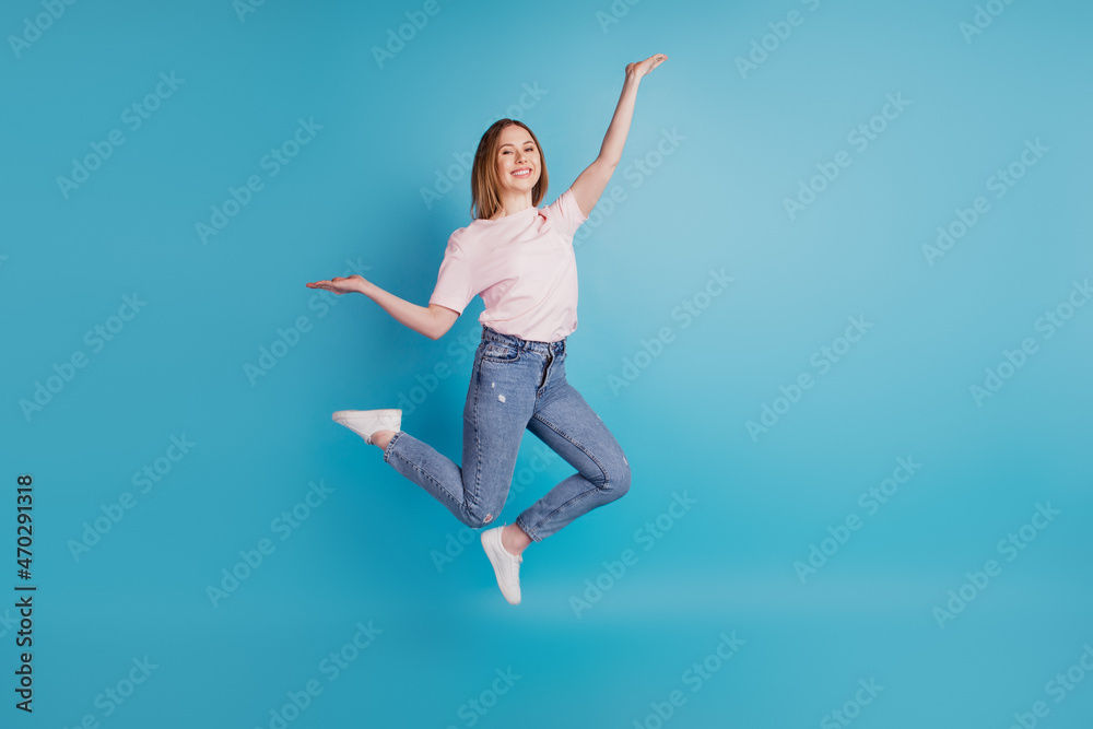 Photo of funny sporty lady jump have carefree fun wear white t-shirt isolated on blue background