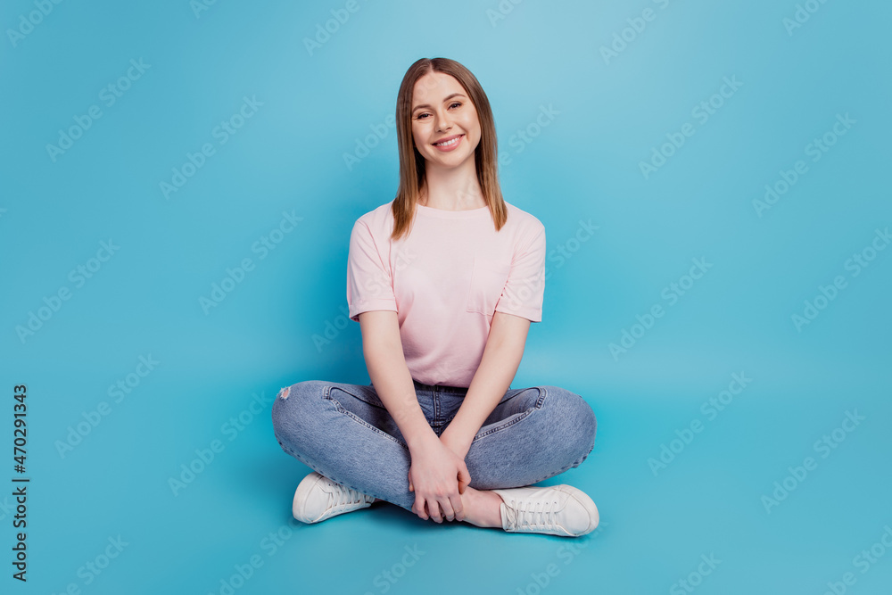 Photo of charming pretty serene calm lady sit floor wear white t-shirt isolated on blue background Photo of charming pretty serene calm lady sit floor wear white t-shirt isolated on blue background