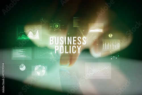 Finger touching tablet with business graphs and icons concept