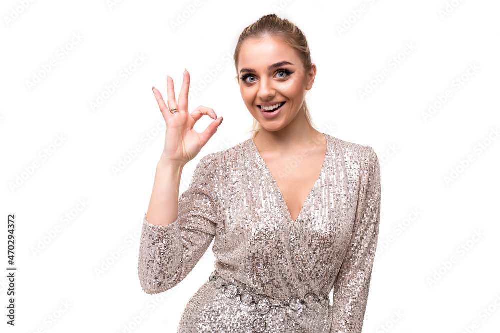 Photo of beautiful attractive charming positive smiling young woman with ponytail and makeup in festive stylish dress with shiny sequins showing ok gesture with hand isolated on white background with Photo of beautiful attractive charming positive smiling young woman with ponytail and makeup in festive stylish dress with shiny sequins showing ok gesture with hand isolated on white background with