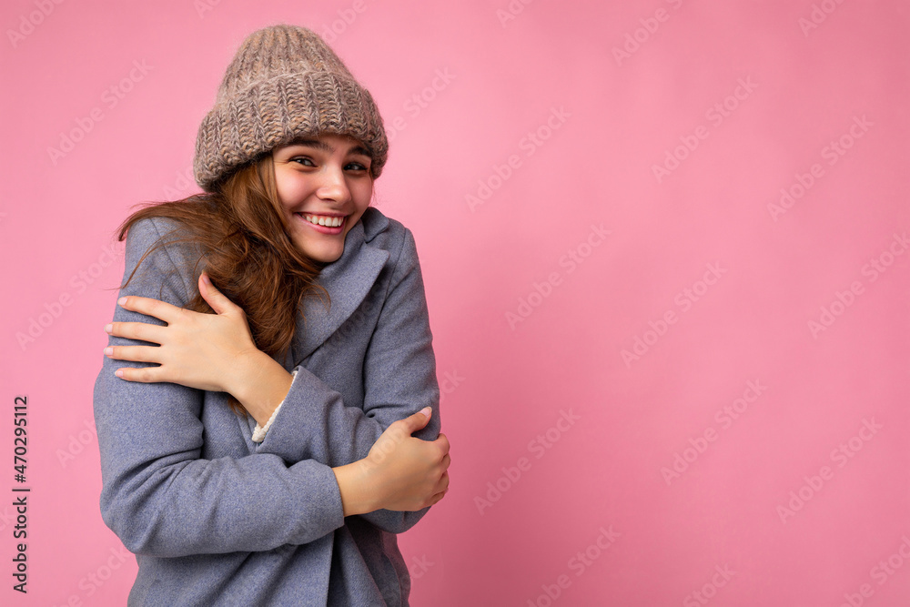 Attractive smiling happy young brunet woman standing isolated over colorful background wall wearing everyday stylish outfit showing facial emotions looking at camera