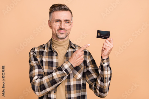 Photo of mature man indciate finger credit card ads advise promo profit isolated over beige color background © deagreez
