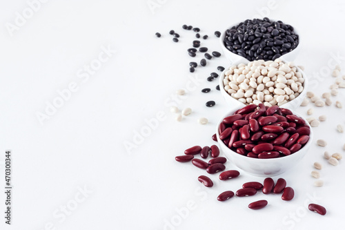 Assortment of beans in a white bowl on white background