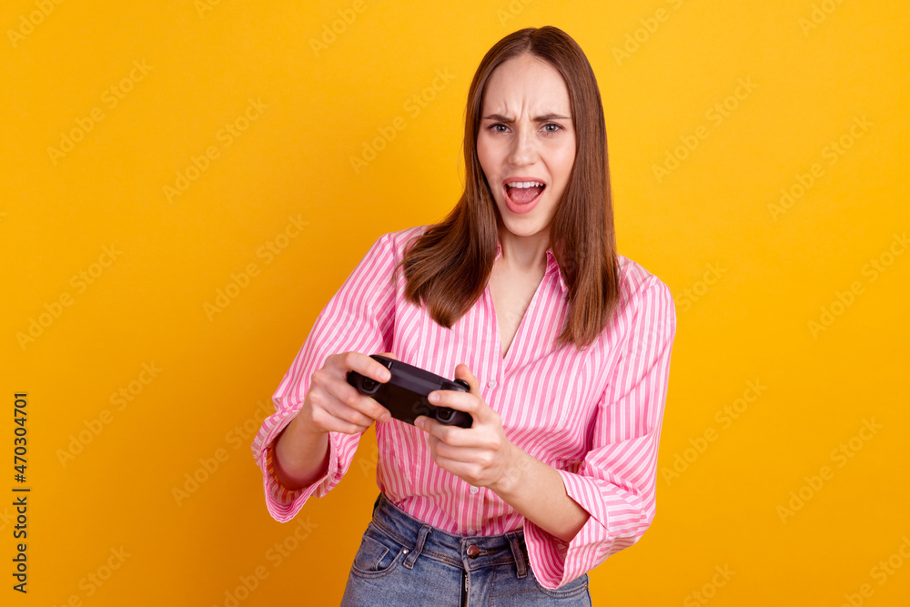 Photo of young attractive lady play video game lose competition joystick isolated over yellow color background Photo of young attractive lady play video game lose competition joystick isolated over yellow color background