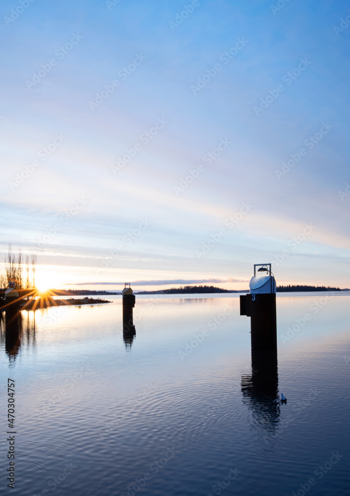 Obraz premium Beautiful sunrise over the lake Mälaren this tranquil winter morning in Sweden. Sky colors reflecting in the calm water.