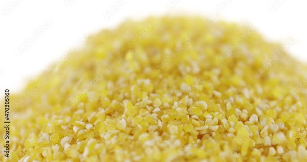 Closeup corn groats falling, isolated on white background. Slow motion. Food background. Closeup corn groats falling, isolated on white background. Slow motion. Food background.