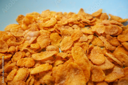 a lot of gluten-free and lactose-free cornflakes are in a blue plate. side view