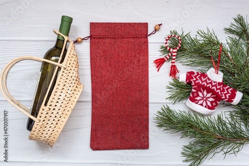 Christmas mockup with wine gift bag and wine bottle with pine branch. New Years Eve Mockup, flatlay, top view. photo