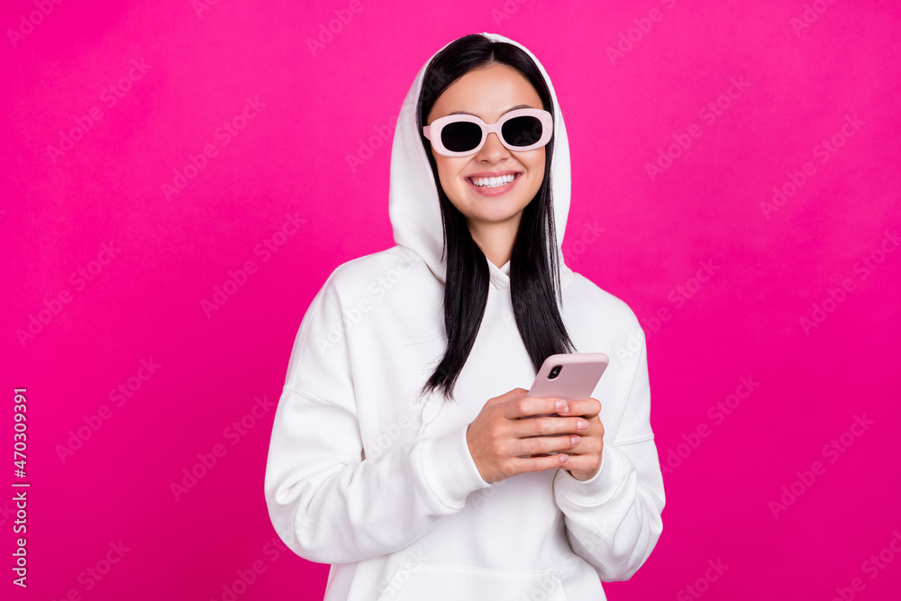 Photo of young cheerful girl use smartphone social network eyewear isolated over magenta color background Photo of young cheerful girl use smartphone social network eyewear isolated over magenta color background