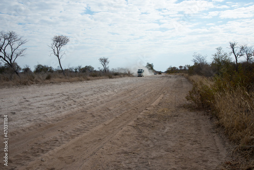 Impressive landscape near Kalahari. Sandy road. Truck, car and crane comming in the distance. Namibia,