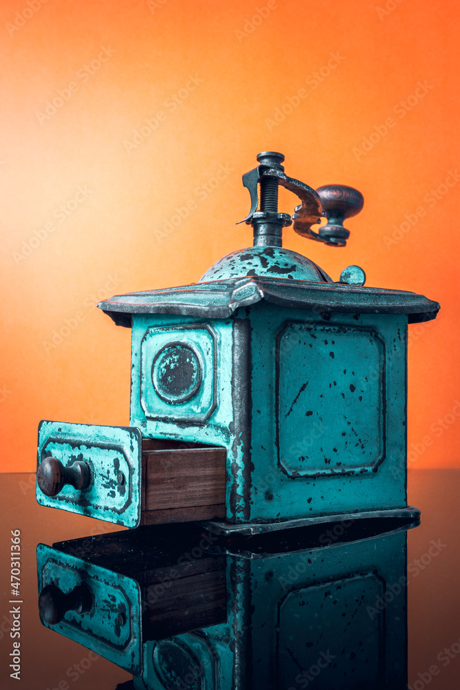 beautiful, turquoise, antique coffee grinder on an orange background