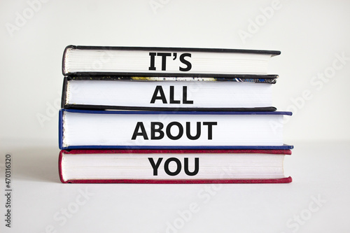 It is all about you symbol. Books with words 'It is all about you'. Beautiful white background. Businessman hand. Copy space. Business and it is all about you concept. photo