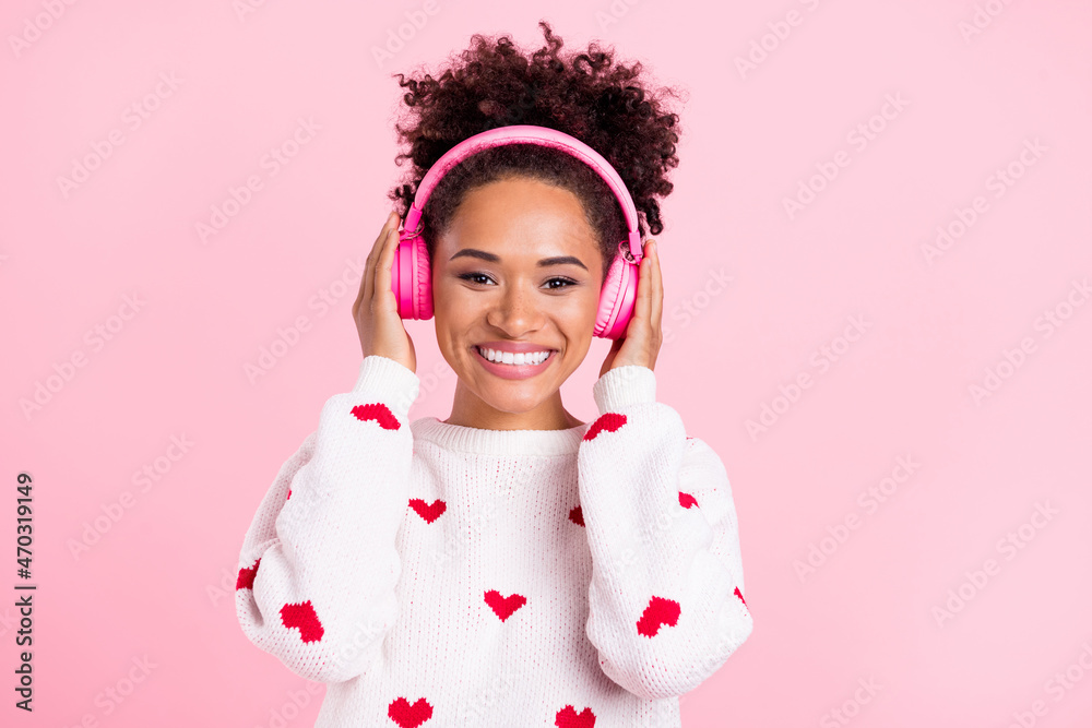 Photo of cheerful charming youth lady hands touch headphones melody isolated over pink color background Photo of cheerful charming youth lady hands touch headphones melody isolated over pink color background