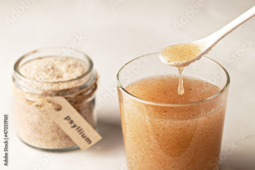 Murais de parede Plantain husk in a jar with the inscription psyllium and a glass of water on a light background