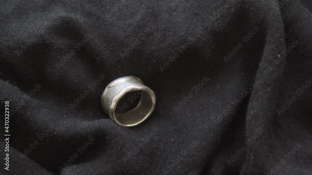 PAN close up of handmade metal ring lying on black cloth PAN close up of handmade metal ring lying on black cloth