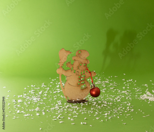 Christmas decoration of snow white with red boble. Creative idea on a green background.