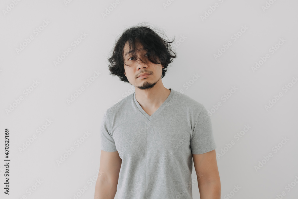 Chill and happy Asian man in his ordinary day with small smile and long hair. Chill and happy Asian man in his ordinary day with small smile and long hair.