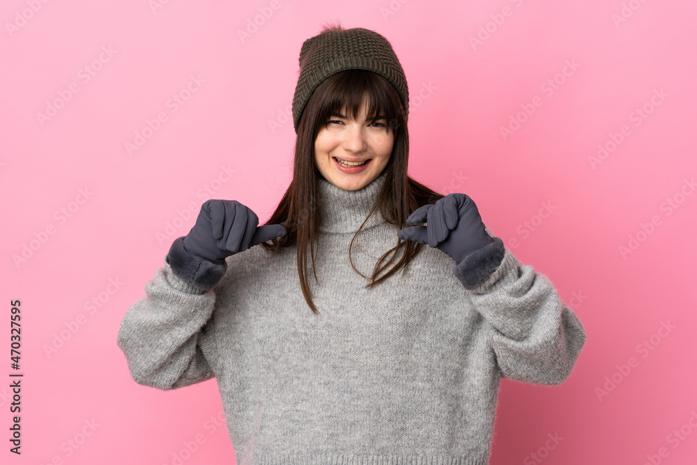 Teenager Ukrainian girl with winter hat isolated on white background proud and self-satisfied