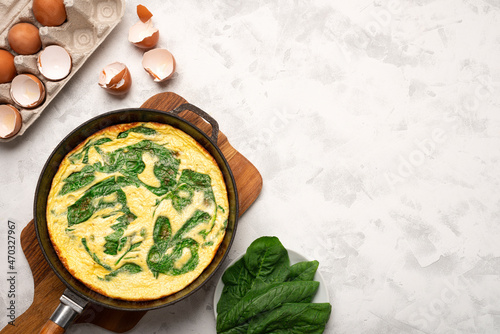 Frying pan SPINACH FRITTATA top view and main ingredients with copy space photo