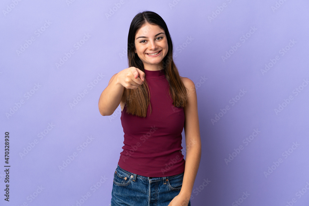 Young caucasian woman isolated on purple background pointing front with happy expression Young caucasian woman isolated on purple background pointing front with happy expression