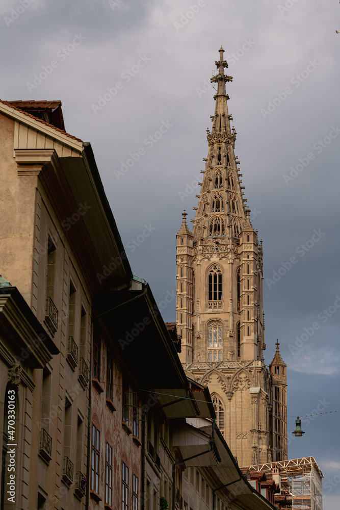 Travel to Switzerland. Berner Münster cathedral with amazing architecture tower photographed during a cloudy morning. Landmark of this city from Bern.