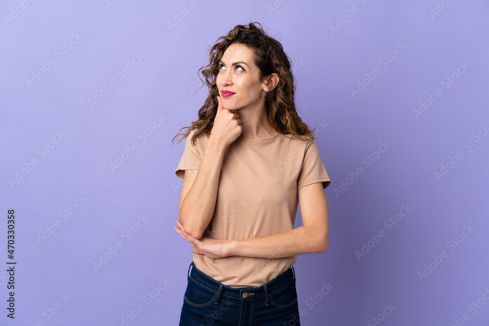Young caucasian woman isolated on purple background thinking an idea while looking up Young caucasian woman isolated on purple background thinking an idea while looking up