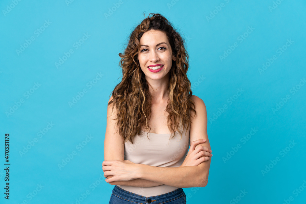 Young caucasian woman isolated on blue background keeping the arms crossed in frontal position - obrazy, fototapety, plakaty 