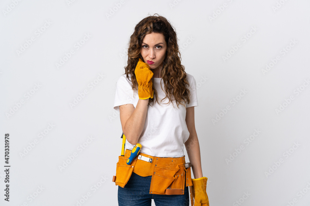 Young electrician man isolated on white background having doubts Young electrician man isolated on white background having doubts