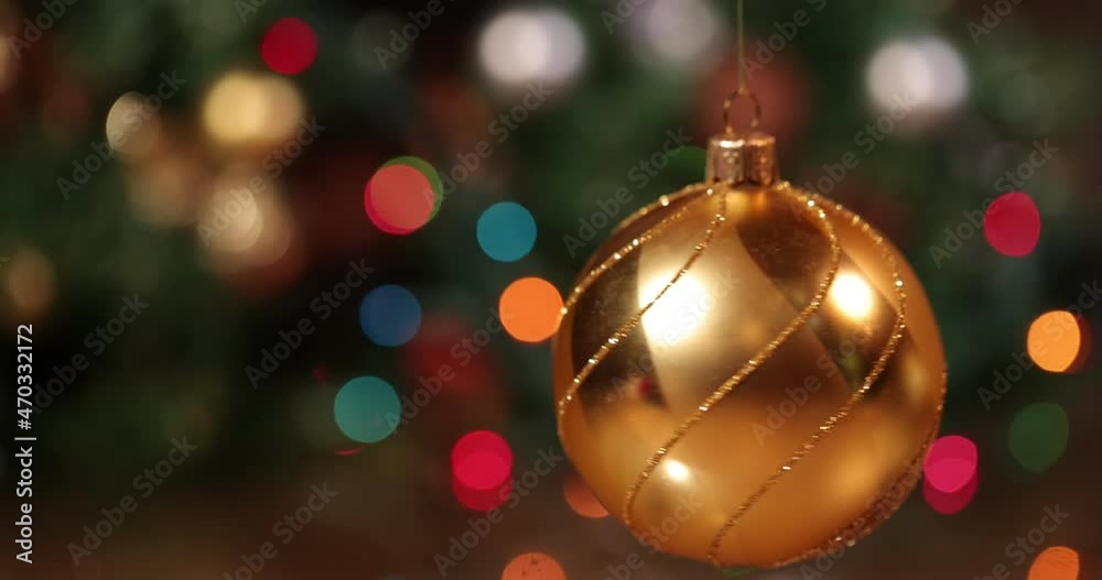 Christmas ball spinning against christmas blur background. Christmas Ornament. Gold christmas balls with bokeh background. Christmas ball spinning against christmas blur background. Christmas Ornament. Gold christmas balls with bokeh background.