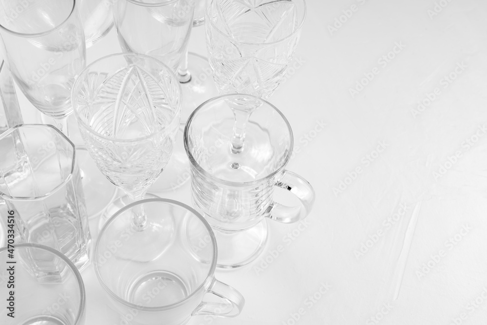 Set of assorted empty drink glasses on white background. Background of empty glasses on white table. Copy space. Top view
