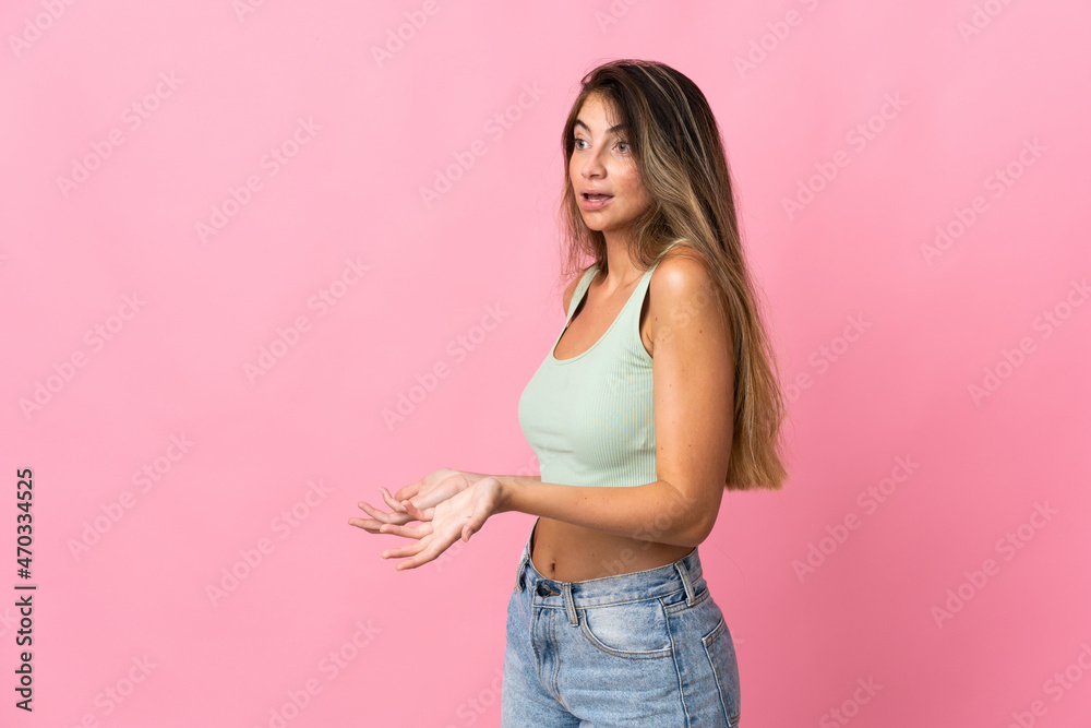 Young caucasian woman isolated on pink background with surprise expression while looking side Young caucasian woman isolated on pink background with surprise expression while looking side