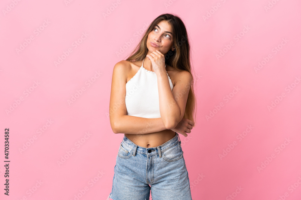 Young caucasian woman isolated on pink background and looking up Young caucasian woman isolated on pink background and looking up
