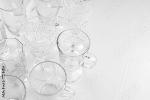 Set of assorted empty drink glasses on white background. Background of empty glasses on white table. Copy space. Top view