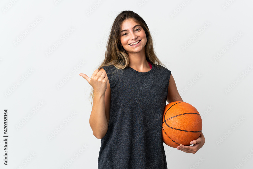 Young woman playing basketball isolated on white background pointing to the side to present a product Young woman playing basketball isolated on white background pointing to the side to present a product