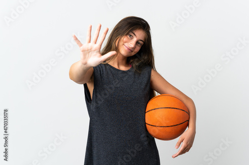 Young woman playing basketball isolated on white background counting five with fingers © luismolinero