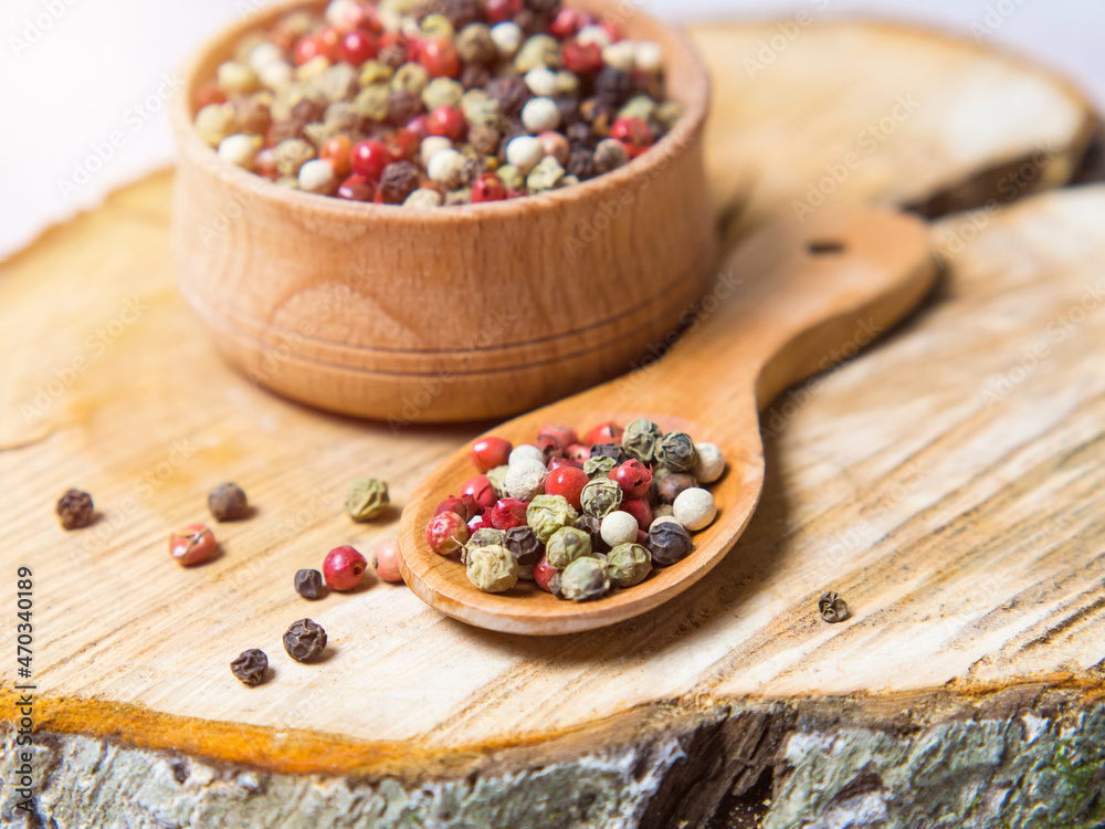 Pepper mix. Black, red, green, white peppercorns spices, Mix of different peppers in a wooden spoon Pepper mix. Black, red, green, white peppercorns spices, Mix of different peppers in a wooden spoon