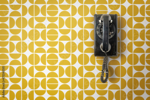 Vintage telephone on mid-century wallpaper