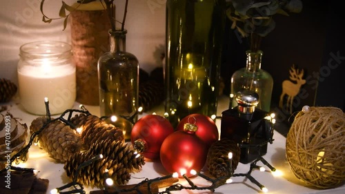 Christmas decorations, flashing lights, New Year 2022 4k background. Xmas tree red balls, gift, candle, fir cones, bottles, deer