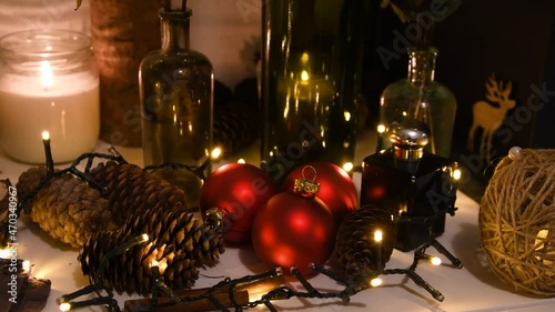Christmas decorations, flashing lights, New Year 2022 4k background. Xmas tree red balls, gift, candle, fir cones, bottles, deer